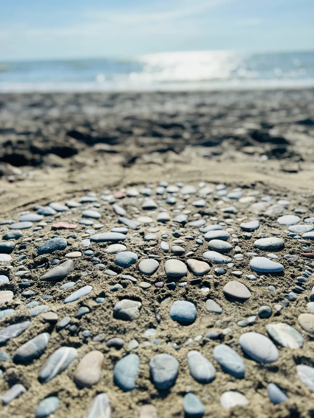 Kieselsteine, im Sand zu einem Kreis gelegt